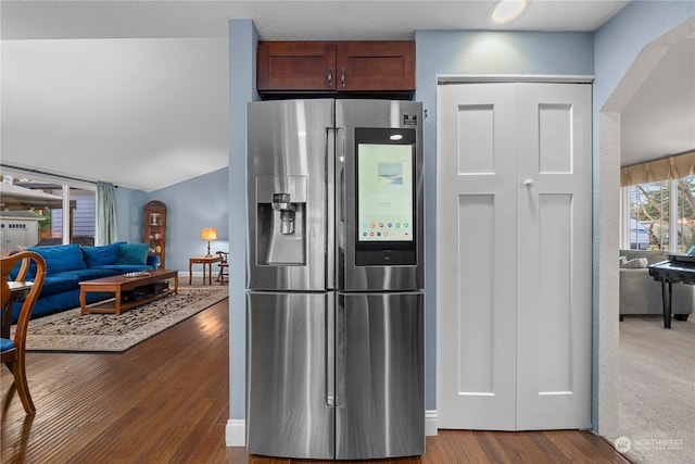 kitchen featuring stainless steel refrigerator with ice dispenser, vaulted ceiling, and dark wood-type flooring