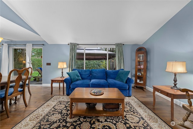 living room featuring dark wood-type flooring and vaulted ceiling