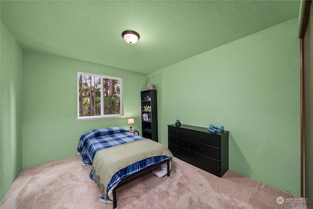 bedroom featuring a textured ceiling and carpet floors