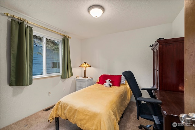 bedroom featuring carpet and a textured ceiling