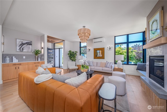 living room featuring an AC wall unit, a tile fireplace, and light hardwood / wood-style flooring