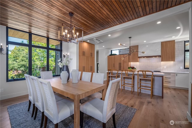 dining space featuring a notable chandelier, light wood-type flooring, and wood ceiling