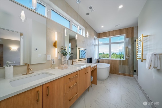 bathroom with vanity and shower with separate bathtub