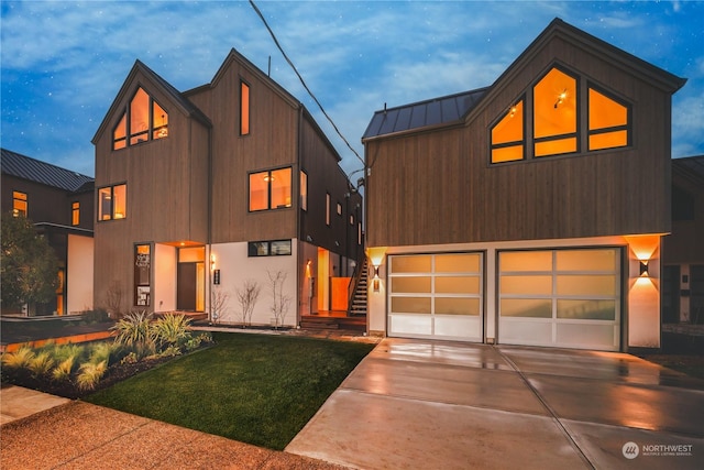 modern home featuring a garage and a lawn