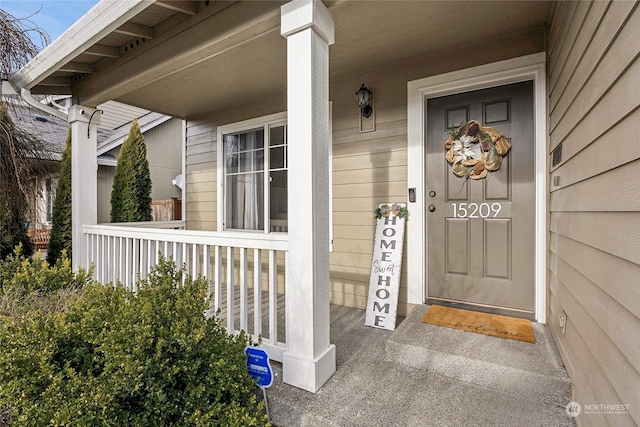 view of exterior entry featuring covered porch