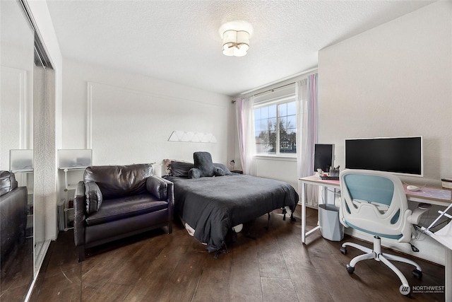 bedroom featuring a textured ceiling, a closet, and dark hardwood / wood-style floors