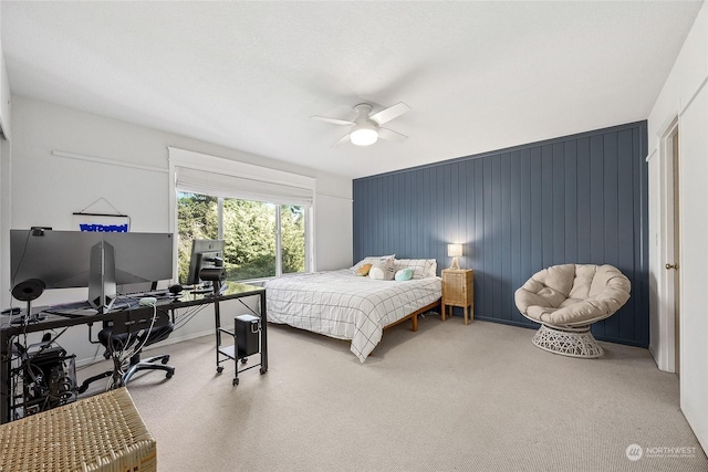 bedroom with ceiling fan and wooden walls