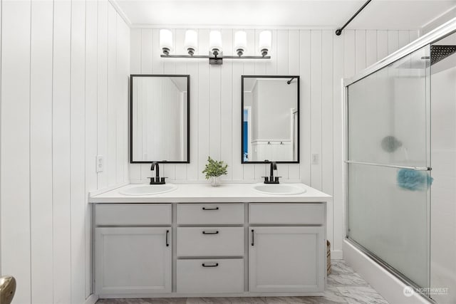 bathroom featuring vanity, a shower with shower door, and wood walls