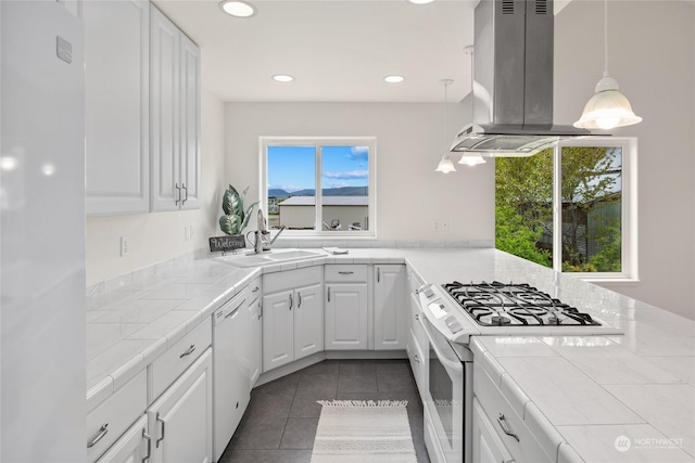 kitchen featuring island exhaust hood, tile countertops, white cabinets, and white appliances