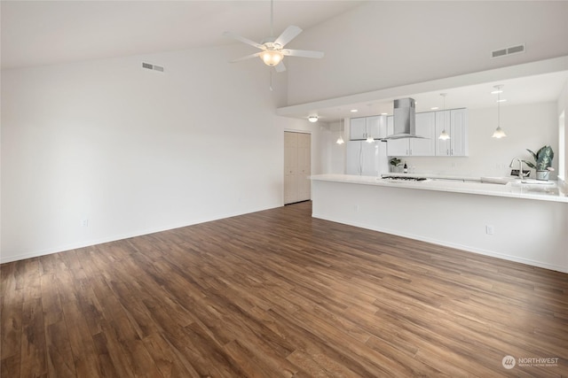 unfurnished living room with ceiling fan, dark hardwood / wood-style flooring, and high vaulted ceiling