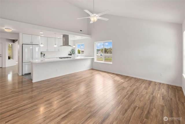 unfurnished living room with ceiling fan, high vaulted ceiling, and hardwood / wood-style floors