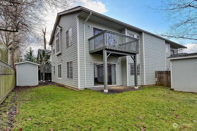 back of house with a balcony, a yard, and a storage unit