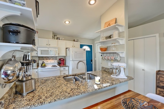 kitchen with white cabinetry, white appliances, lofted ceiling, light stone counters, and sink