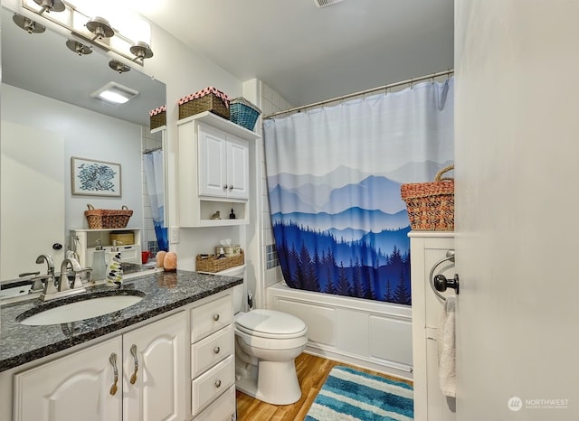 full bathroom featuring shower / bath combo with shower curtain, hardwood / wood-style floors, toilet, and vanity