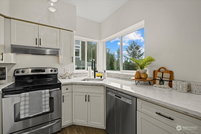 kitchen featuring light stone countertops, stainless steel appliances, white cabinetry, and sink