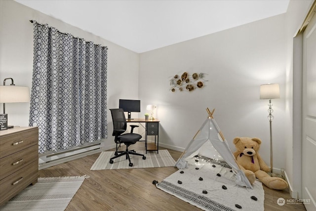 office space featuring light wood-type flooring and a baseboard radiator