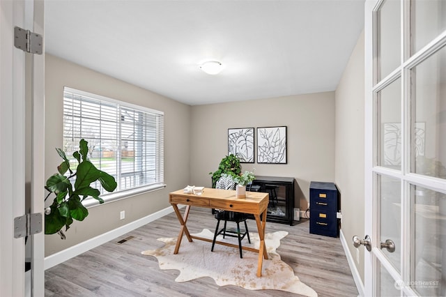 office with a healthy amount of sunlight and light wood-type flooring