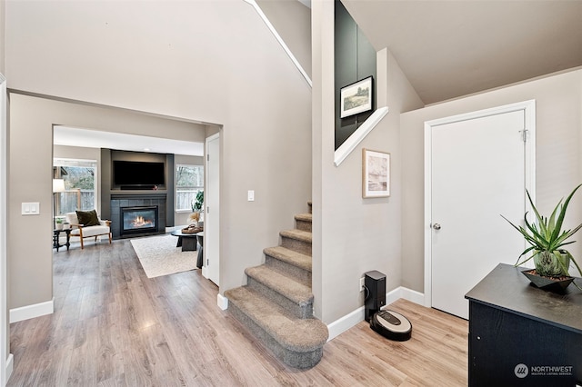 entrance foyer featuring a tiled fireplace and light wood-type flooring