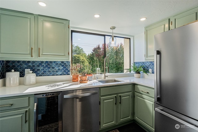 kitchen featuring sink, wine cooler, decorative light fixtures, appliances with stainless steel finishes, and green cabinetry