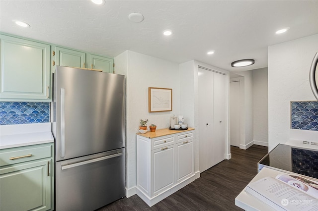 kitchen featuring decorative backsplash, stainless steel fridge, and dark wood-type flooring