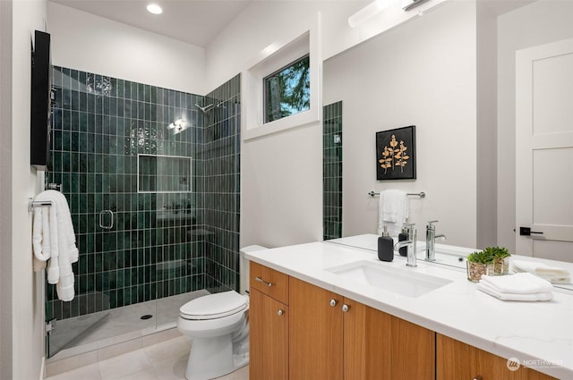 bathroom with tile patterned floors, toilet, vanity, and walk in shower