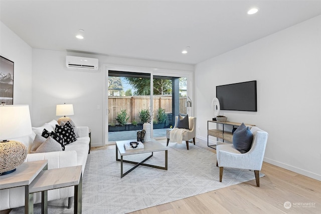 living room featuring an AC wall unit and light hardwood / wood-style floors