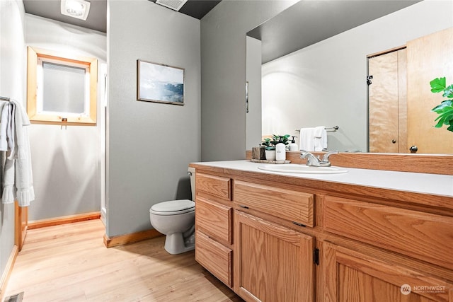 bathroom with hardwood / wood-style flooring, vanity, and toilet