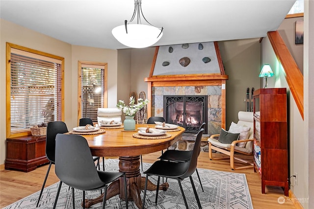 dining room featuring light hardwood / wood-style floors and a tile fireplace