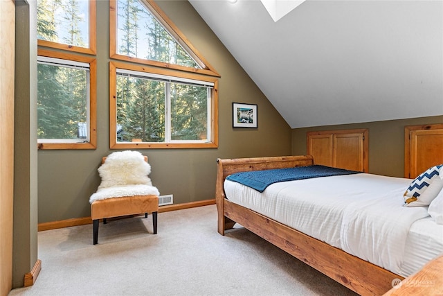 bedroom featuring light carpet and vaulted ceiling with skylight