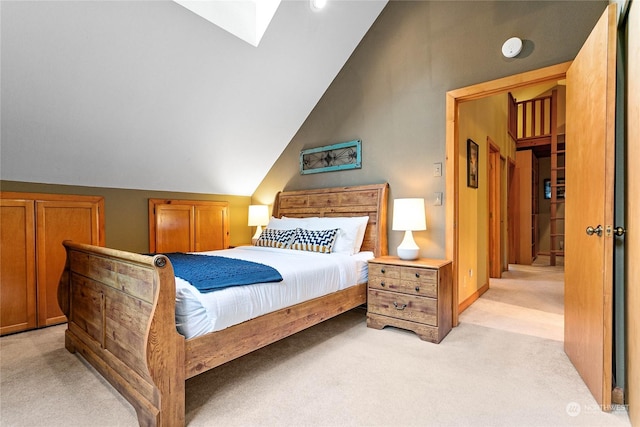 carpeted bedroom featuring vaulted ceiling with skylight