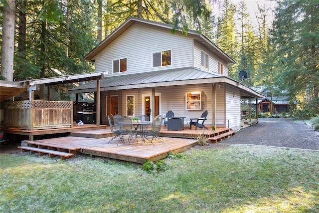 rear view of house with a deck and a lawn