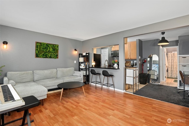 living room with light hardwood / wood-style flooring and sink