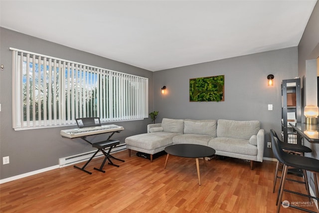 living room with light hardwood / wood-style flooring and a baseboard heating unit