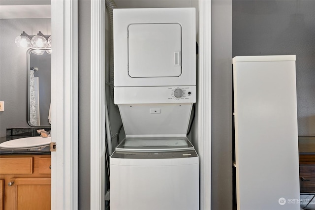 laundry area featuring stacked washer / dryer and sink