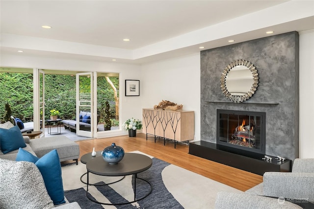 living room featuring wood-type flooring and a large fireplace