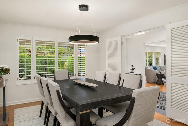 dining room featuring light hardwood / wood-style floors and crown molding