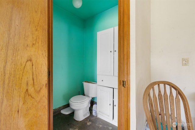 bathroom with concrete flooring and toilet