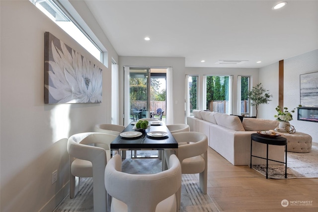 dining room featuring a fireplace and light wood-type flooring