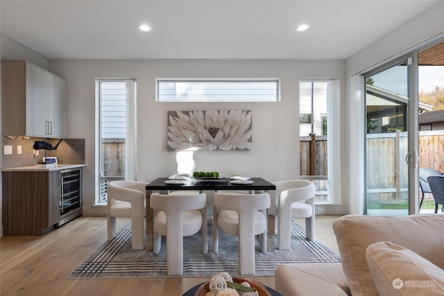 dining space featuring light hardwood / wood-style floors and beverage cooler