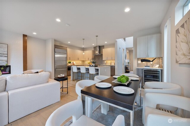 dining room featuring wine cooler and light wood-type flooring