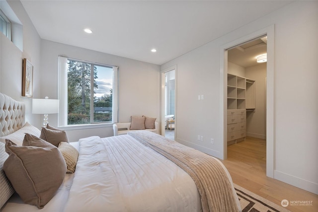 bedroom featuring light hardwood / wood-style floors, a spacious closet, and a closet