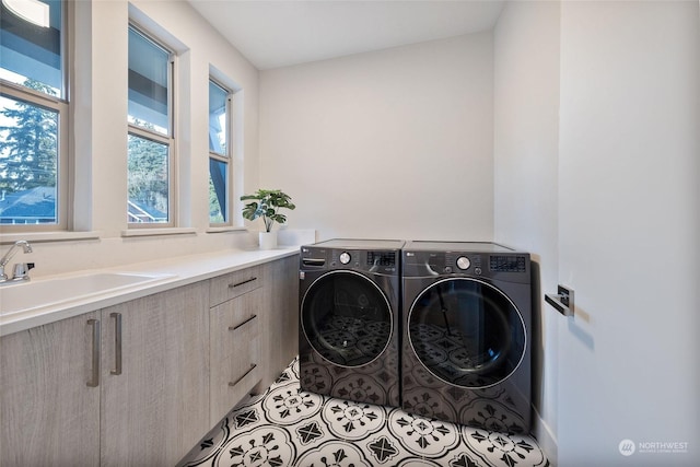 washroom with separate washer and dryer, sink, light tile patterned floors, and cabinets