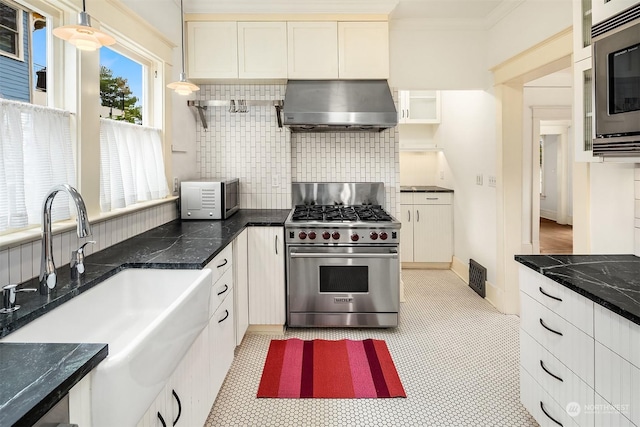 kitchen with sink, appliances with stainless steel finishes, ventilation hood, white cabinets, and decorative light fixtures