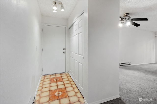 hall featuring carpet flooring, a textured ceiling, and a baseboard radiator