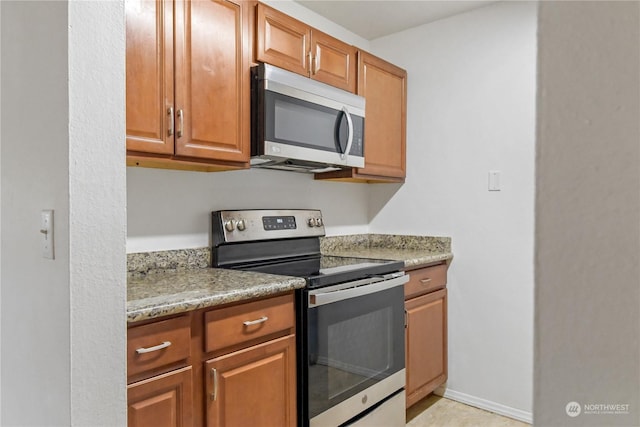 kitchen with light stone counters and stainless steel appliances