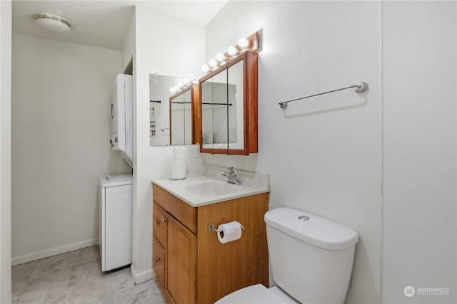 bathroom featuring vanity, stacked washer and dryer, and toilet