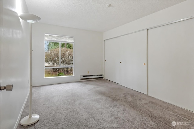 unfurnished bedroom with a textured ceiling, carpet floors, a closet, and baseboard heating