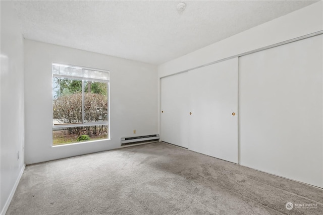 unfurnished bedroom featuring multiple windows, a baseboard radiator, a closet, and light colored carpet