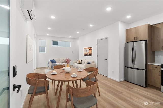 dining room featuring light hardwood / wood-style floors and an AC wall unit