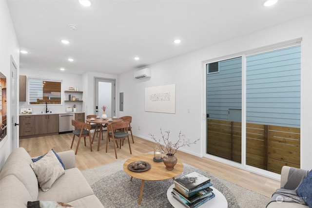 living room featuring a wall mounted air conditioner, light wood-type flooring, sink, and electric panel